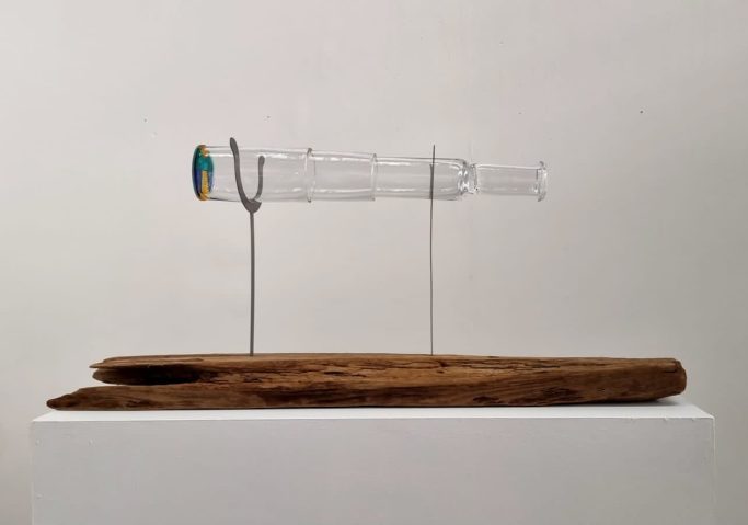 Handblown clear glass telescope, resting on steel oars set into driftwood.
